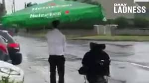 Barman Uses Pub Umbrella To Escort Customer Home In Pouring Rain