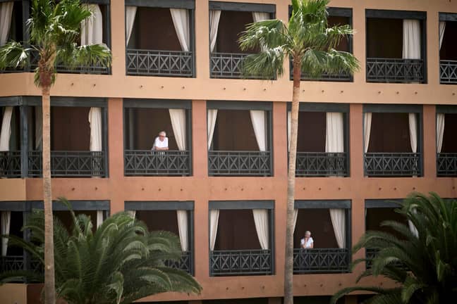 People stand at their balconies at the H10 Costa Adeje Palace hotel in Tenerife. Credit: PA