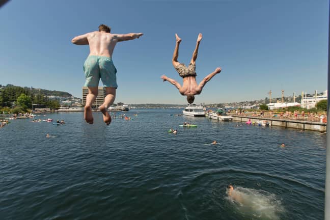 Two people jump from a pedestrian bridge at Lake Union Park, Seattle. Credit: PA