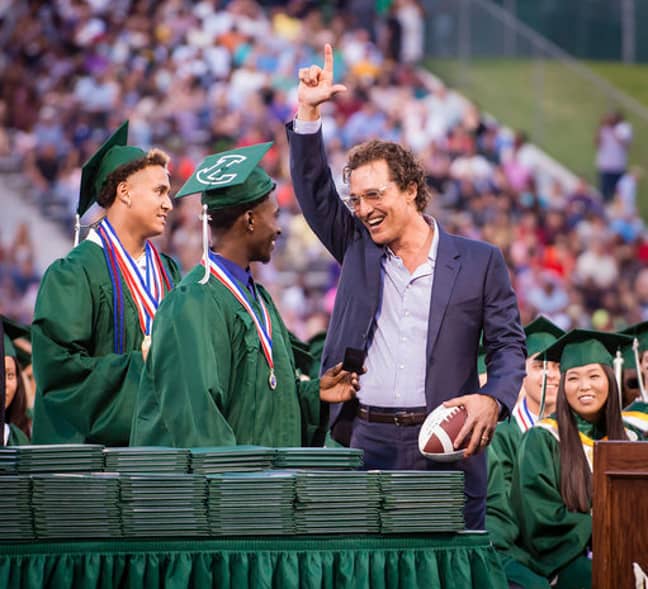 Kamden Perry, left, and Jephaniah Lister present actor Matthew McConaughey with an autographed football at the school's graduation ceremony. Credit: PA