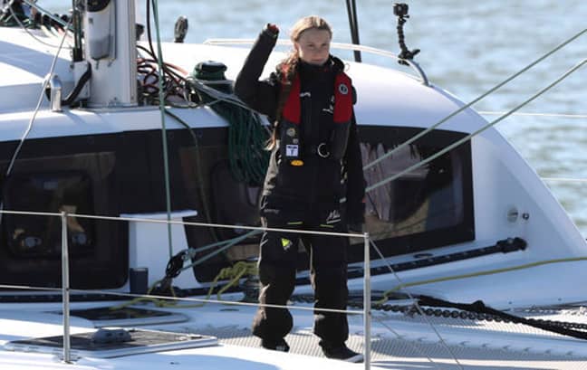 Thunberg waves as she arrives in Lisbon. Credit: PA