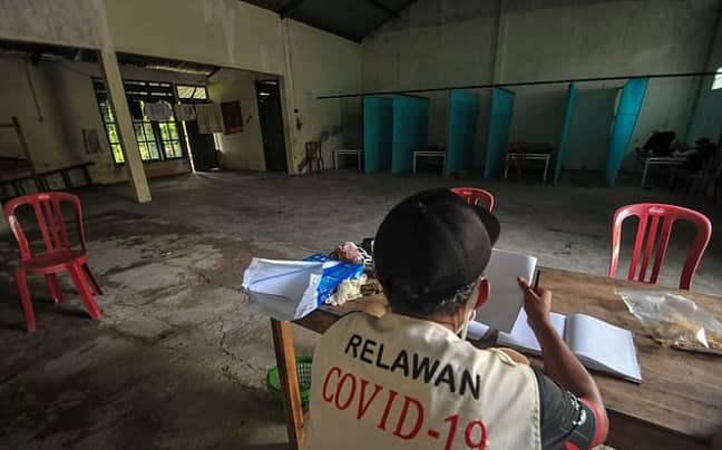 A volunteer at one of the abandoned houses repurposed as quarantine facilities in at Sepat village in Sragen, Central Java. Credit: ANWAR MUSTAFA/AFP via Getty Images