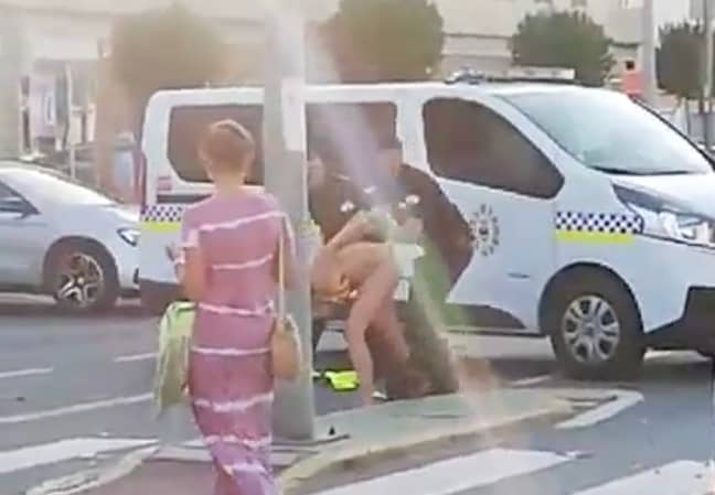 The woman can be seen to resist arrest in the footage. Credit: Solarpix