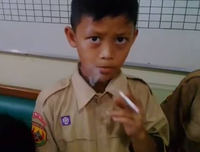 One of the children smoking after his headteacher gave him a cigarette as punishment. Credit: Newsflare