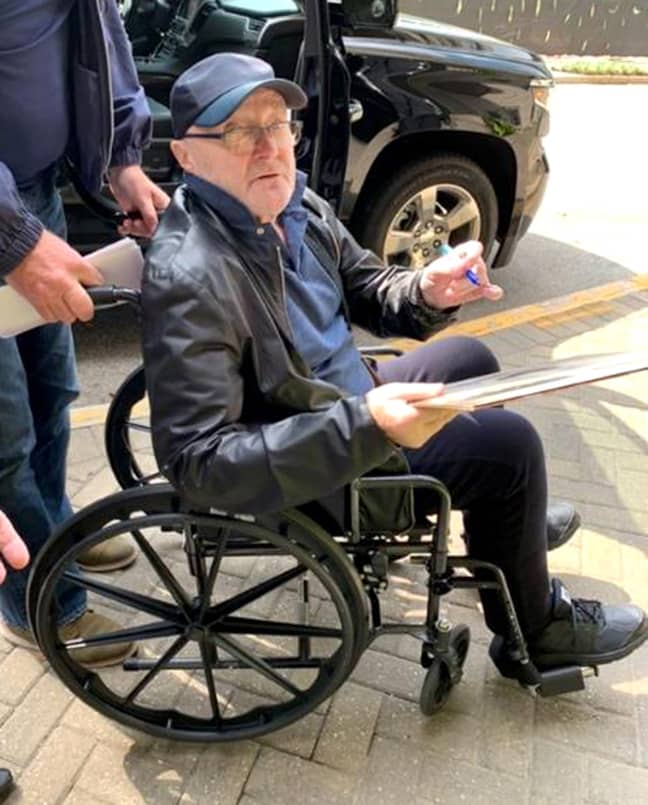 Phil Collins looks frail in a wheelchair following a fall on-stage. Credit: Splash News
