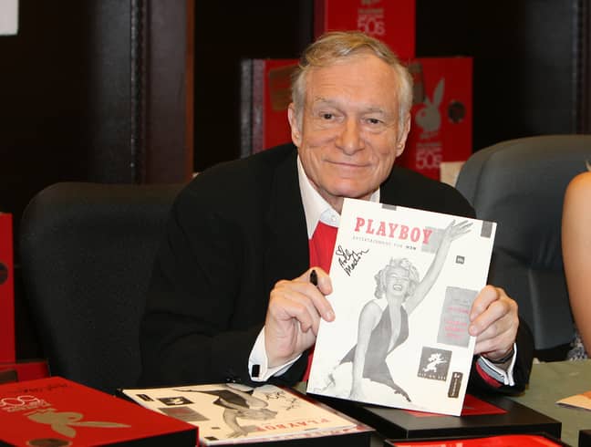The late Hugh Hefner signing copies of Playboy. Credit: PA