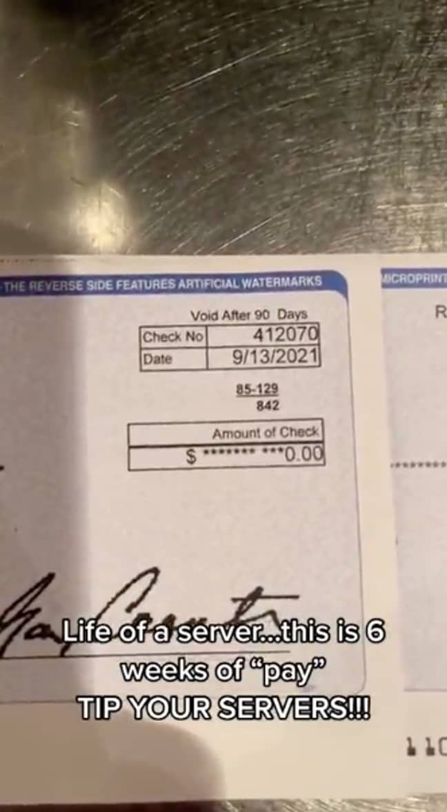 Сервитьорка показва фиша от заплатата си на стойност една стотинка.