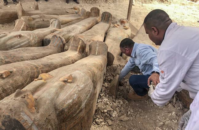 Secretary General of the Supreme Council of the Egyptian Antiquities, Mustafa Wazir (L), inspects a coffin. Credit: PA