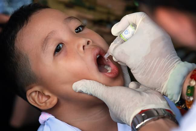A boy receives an oral poliovirus vaccine during an anti-polio campaign. Credit: PA