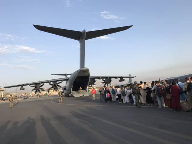 People queue up to board a German military aircraft at Kabul airport. Credit: PA