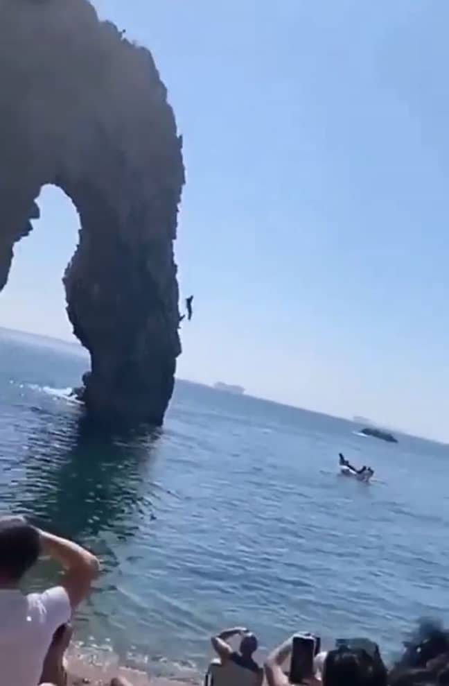 People watch on as someone dives from Durdle Door in Dorset. Credit: Snapchat