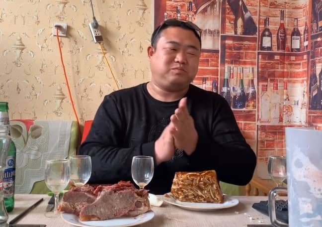 Pangzai claps at his feast. Credit: YouTube/Pangzai