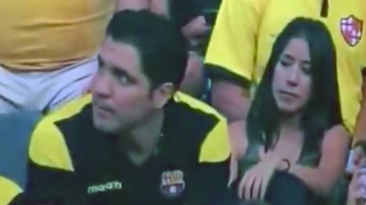 ​Man Has Weirdly Awkward Reaction To Being Caught Kissing On Camera At Football Game